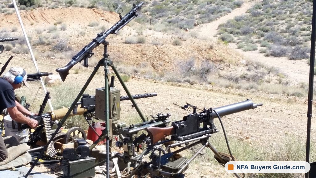 Belt-fed machine guns on tripods ready on the firing line
